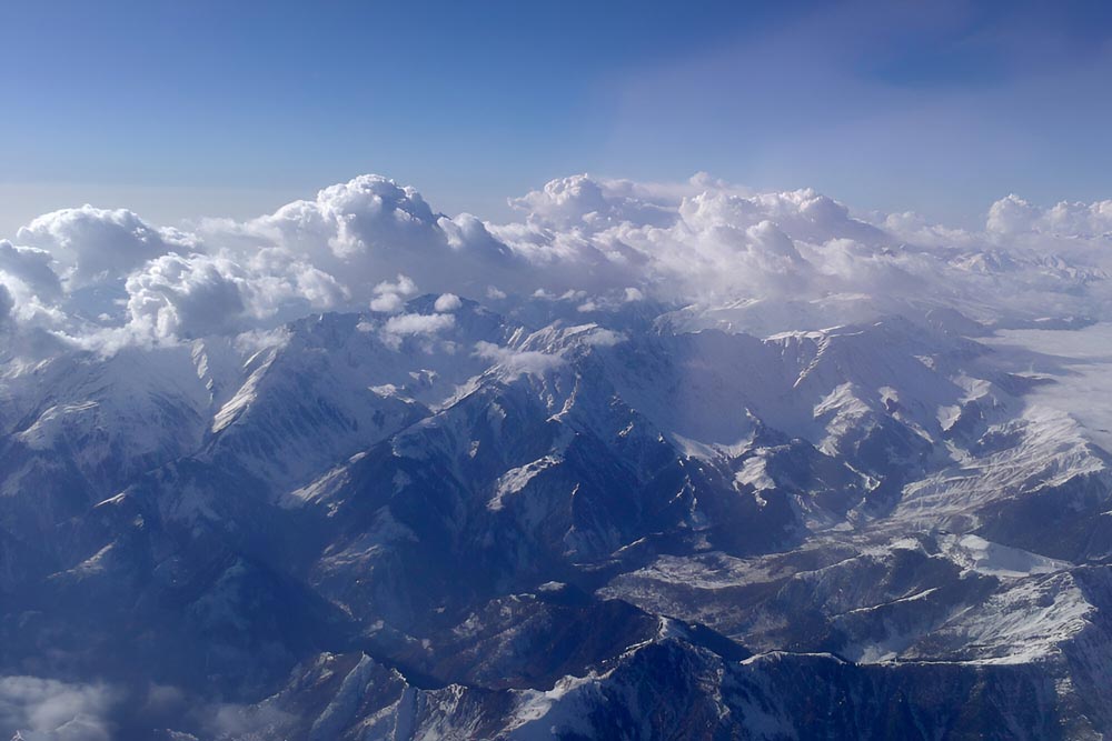 Flygvy över bergskedja i Indien under en klarblå himmel.