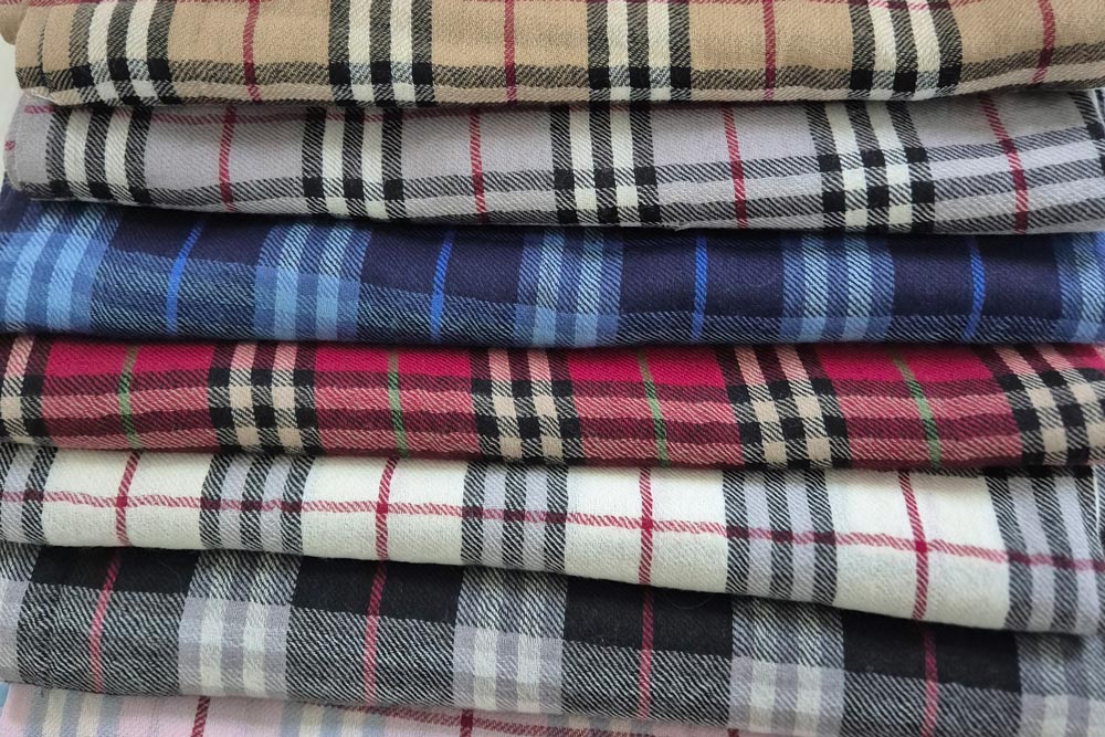 Flera sjalar för män i olika färger vikta i en hög